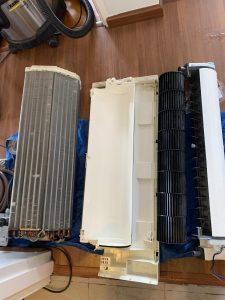 Disassembled aircon components including evaporator coil and blower fan during overhaul service