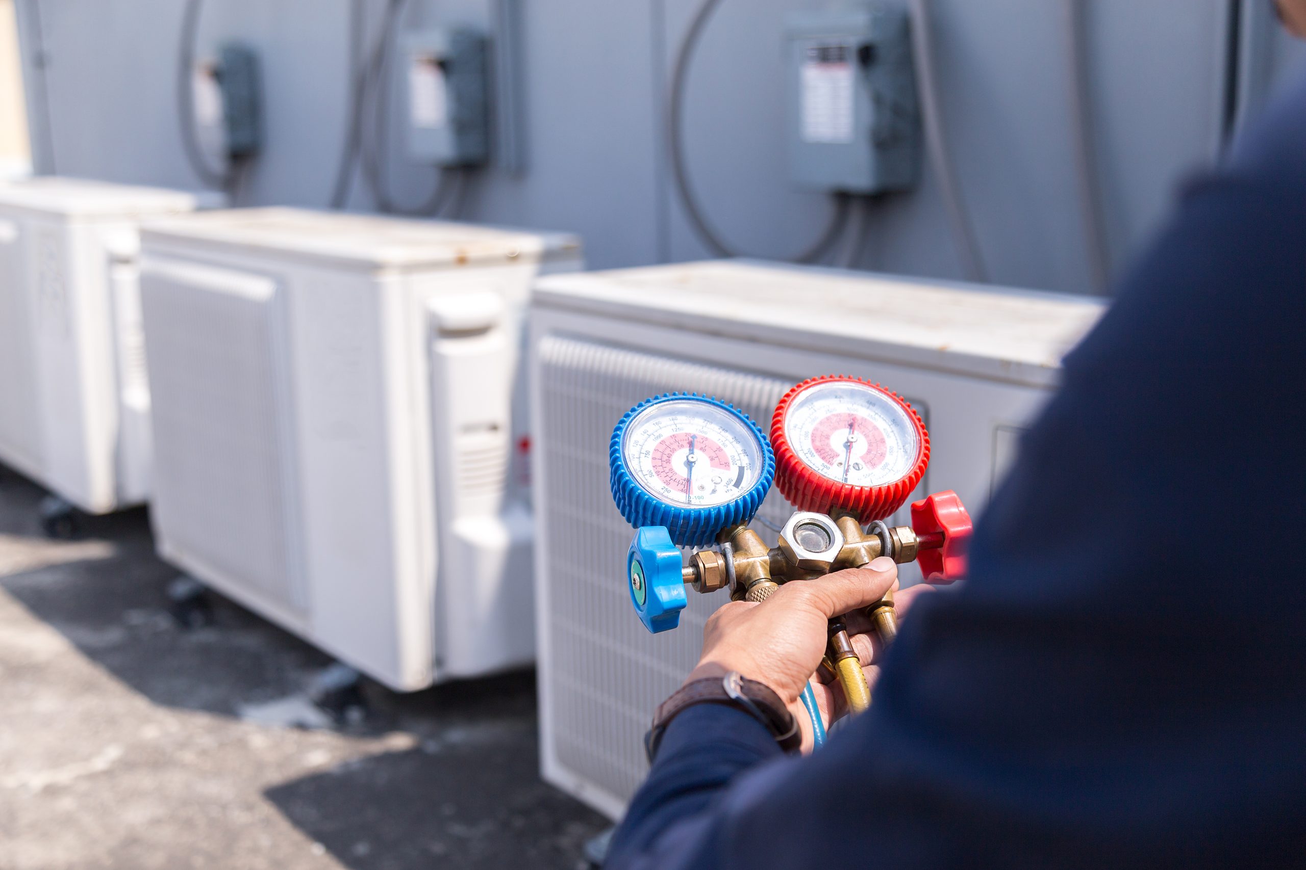 Technician checking air conditioner gas pressure using manifold gauge sets