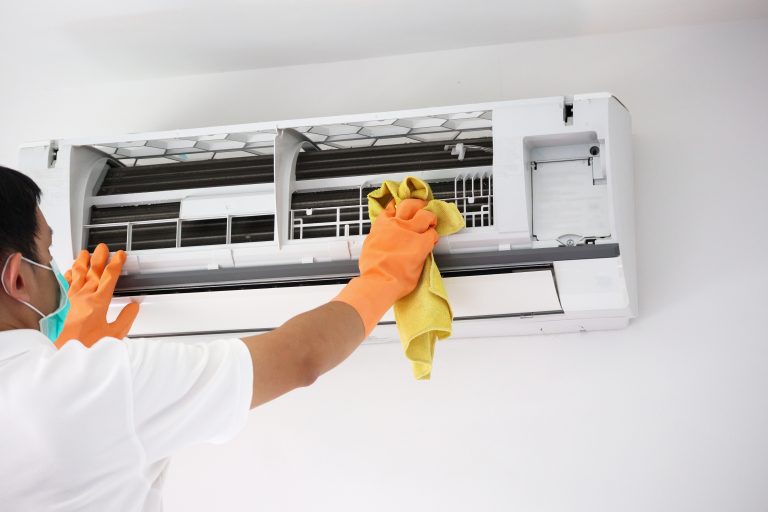 Skilled technician cleaning aircon fins and vents during general servicing in Singapore