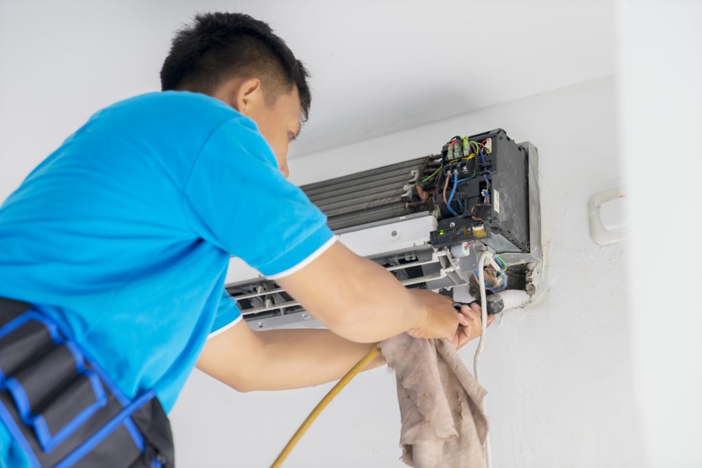 CoolAire technician providing residential aircon servicing and deep cleaning to improve cooling efficiency